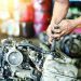 Close up hand of attractive man working hard and fix Auto mechanic on car engine in mechanics garage. Repair service